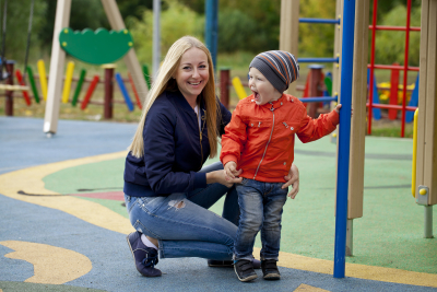 woman smiling with a little boy in the playground